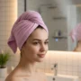 Ultra absorbent microfiber hair towel turban wrap with button closure shown on a woman drying her hair naturally.