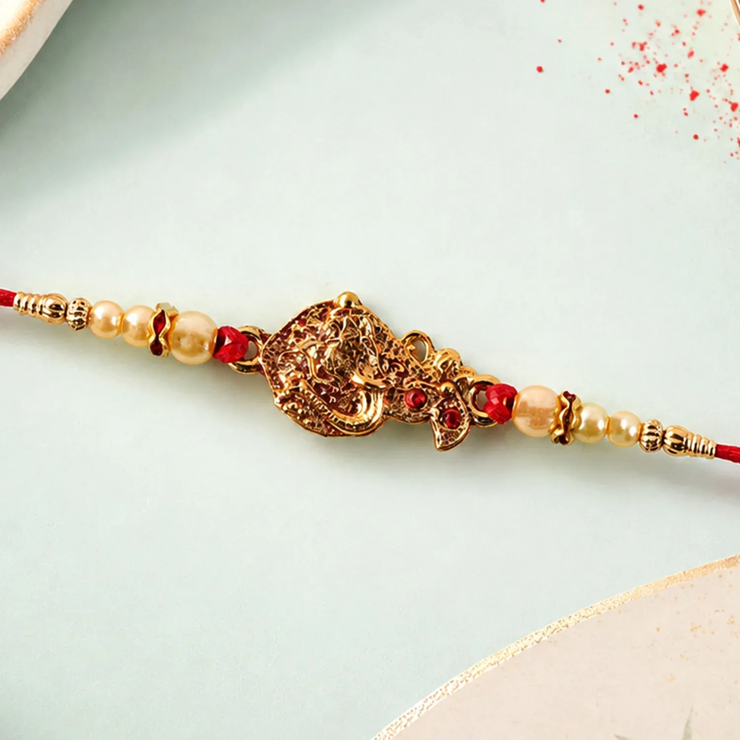 Golden Peacock Rakhi – Pearl Beads & Red Thread for Brother on Raksha Bandhan - Detailed Feature View 2