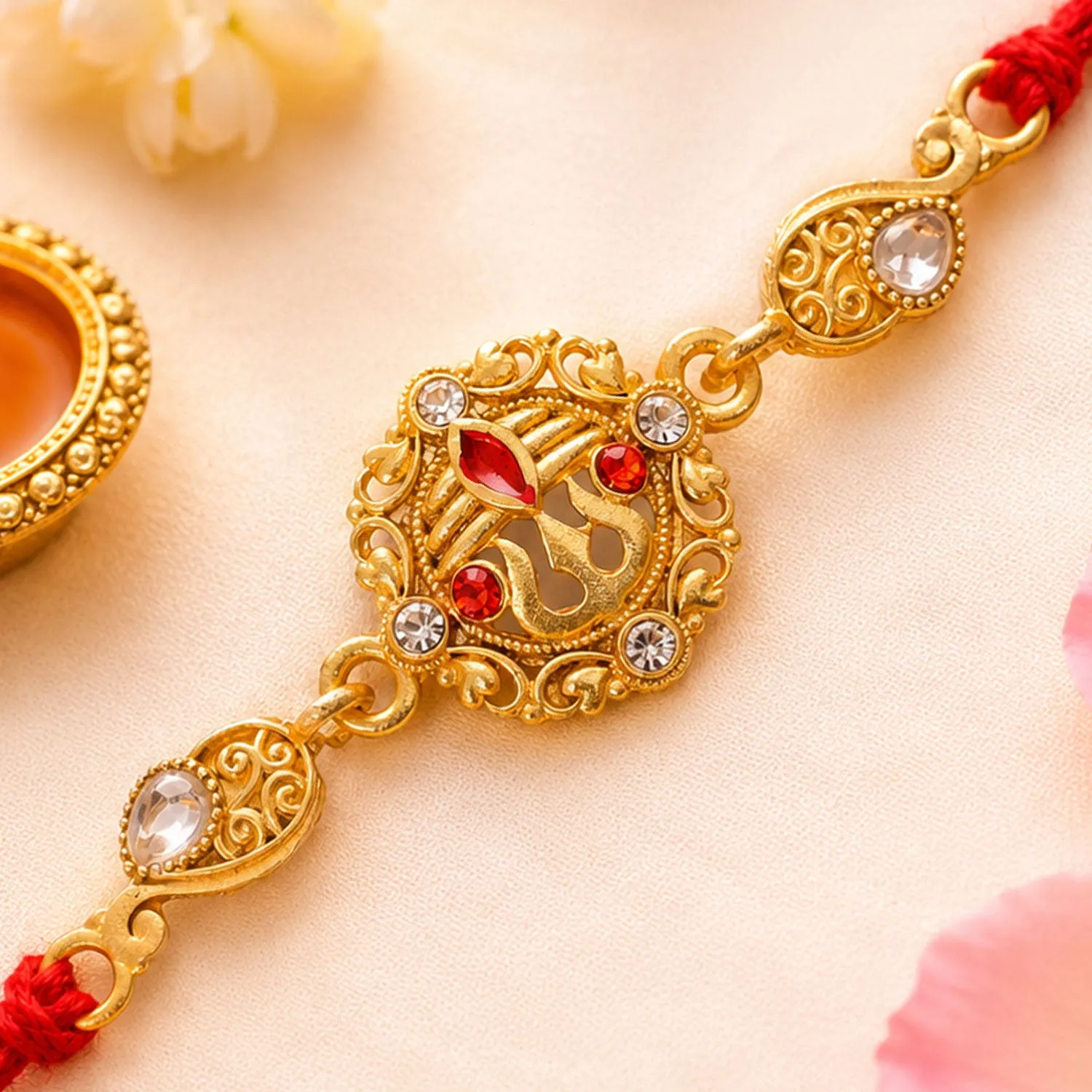 Premium Gold-Toned Trishul Rakhi with Red Stones, Clear Crystal Accents & Designer Red Thread - Buy Online at Alikart