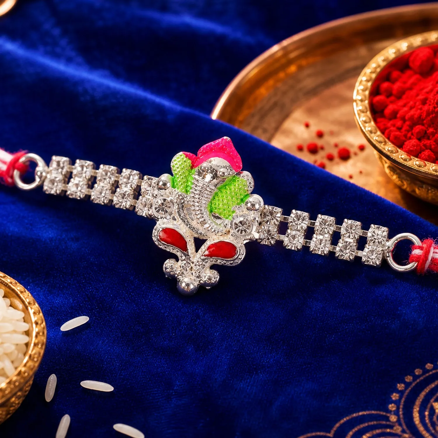 Premium Silver-Toned Lord Ganesha Rakhi with Pink-Green Enamel, Double Crystal Chain & Red-White Thread - Buy Online at Alikart