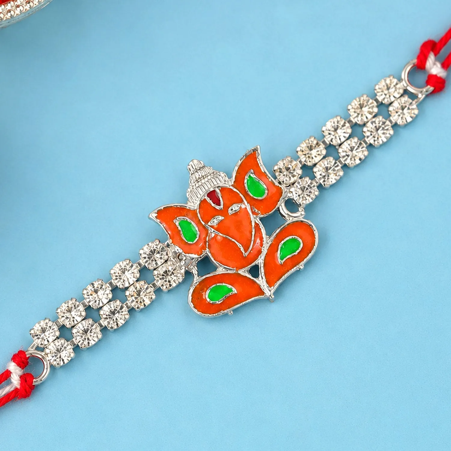 Premium Silver-Toned Lord Ganesha Rakhi with Orange-Green Enamel, Double Crystal Chain & Red Thread - Buy Online at Alikart