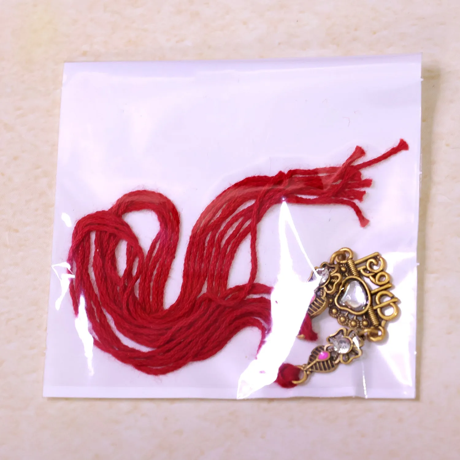Antique Gold-Toned Kanha Rakhi with Kundan-Style Stone, Crystal Accents & Red Thread - Detailed Feature View 5