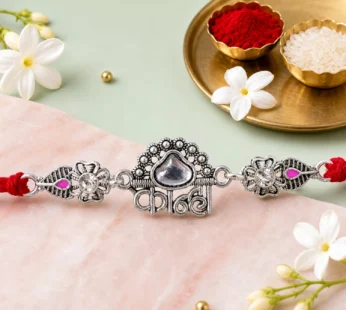 Silver-Toned Kanha Rakhi with Kundan-Style Stone, Crystal Accents & Designer Red Thread