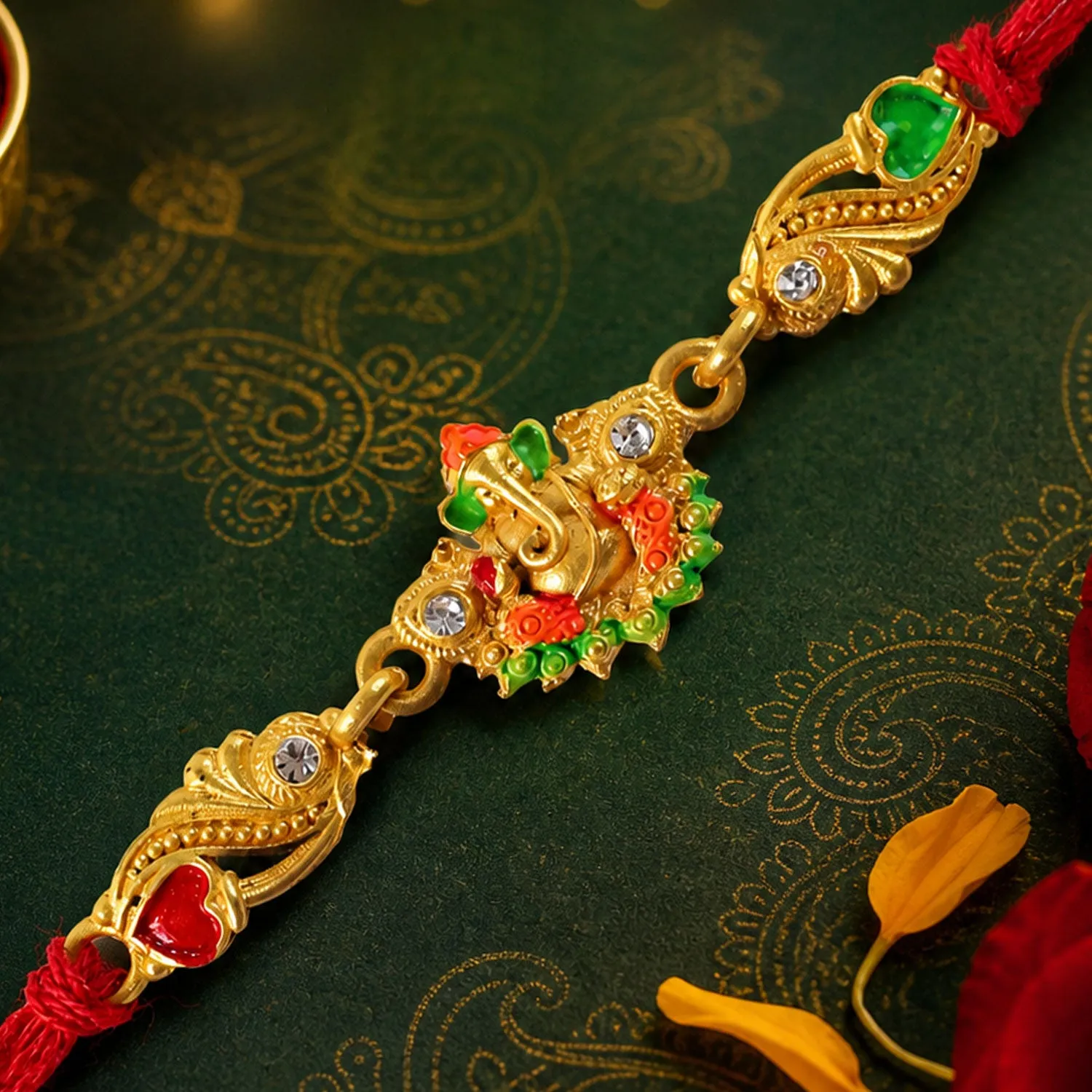 Premium Gold-Toned Lord Ganesha Rakhi with Orange-Green Enamel, Crystal Accents & Red Thread - Buy Online at Alikart
